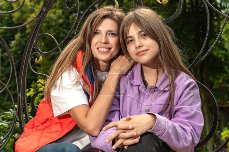 Photo for Young woman with teenage daughter in summer park. Happy mother with her daughter - Royalty Free Image
