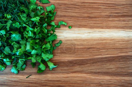 Photo for Fresh green dill and cilantro on a wooden cutting board. Food and cooking concepts - Royalty Free Image
