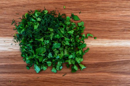 Photo for Fresh green dill and cilantro on a wooden cutting board. Food and cooking concepts - Royalty Free Image