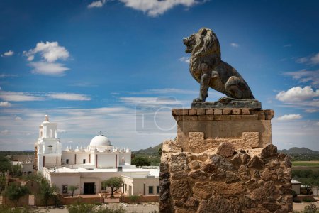 Foto de A statue stands next to the Spanish mission, San Xavier del bac, built in 1797 near Tucson, Arizona. - Imagen libre de derechos