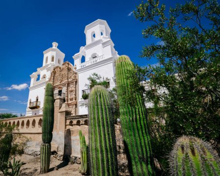 Foto de Cactus stand in front of the Spanish mission, San Xavier del bac, built in 1797 near Tucson, Arizona. - Imagen libre de derechos
