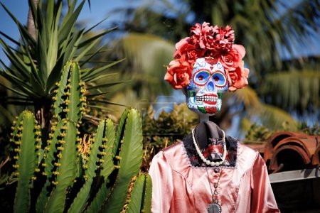 Téléchargez les photos : A Day of the Dead woman se tient à côté d'un cactus dans la vieille ville de San Diego, Californie. - en image libre de droit