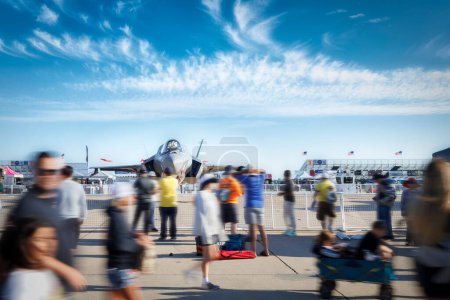 Téléchargez les photos : La foule sortant du Americas Airshow 2023 passe un F35 Lightning II sur leur chemin du salon aérien. - en image libre de droit