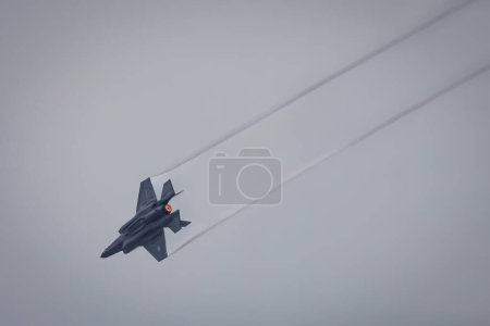 Photo for An F-35 Lightning II leaves a vapor trail in a steep dive on an overcast day at America's Airshow 2023 in Miramar, California. - Royalty Free Image