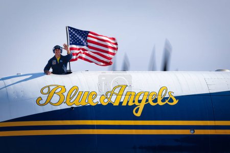 Téléchargez les photos : Un membre d'équipage de Fat Albert, l'avion de soutien de l'US Navy Blue Angel, salue la foule lors du salon America Airshow 2023 à Miramar, Californie. - en image libre de droit