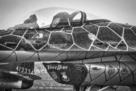 Téléchargez les photos : Un F-16, de l'équipe de démonstration Viper de l'armée de l'air américaine, tombe sous la pluie alors qu'il est assis sur le tarmac au salon aérien de l'Amérique à Miramar, en Californie. - en image libre de droit