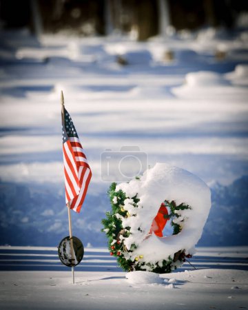 Photo for An American flag in a cemetery with fresh snowfall at a northern Wisconsin cemetery. - Royalty Free Image