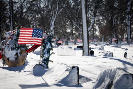 Photo for American flags in a windy cemetery with fresh snowfall at a northern Wisconsin cemetery. - Royalty Free Image