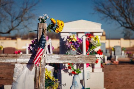 Foto de Una bandera y flores en una tumba en el cementerio de La Isla cerca de Fabens, Texas. - Imagen libre de derechos
