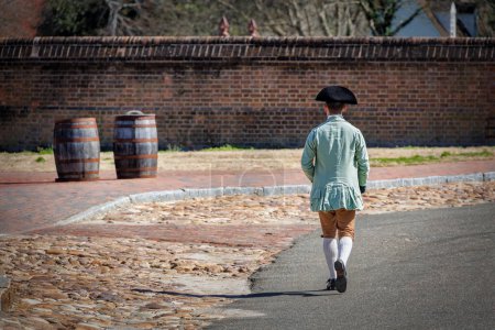 Photo for A man walks down the street, in period clothing, at Colonial Williamsburg, Virginia. - Royalty Free Image