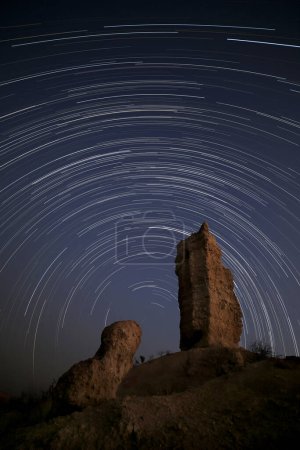 Foto de Un largo sendero estelar atraviesa el cielo nocturno sobre el Vingerklipp, Damaraland, Namibia. - Imagen libre de derechos
