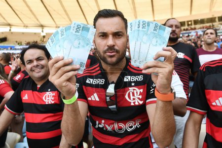 Photo for Rio de Janeiro, Brazil, May 12, 2024. A Flamengo fan protests against the team, showing money, at the Maracan stadium in the city of Rio de Janeiro. - Royalty Free Image