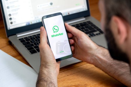 Foto de Logotipo de la aplicación WhatsApp en la pantalla del teléfono en las manos de un hombre. Smartphone con pantalla de fondo blanco y logotipo verde. SYDNEY, AUSTRALIA - 10 DE NOVIEMBRE DE 2022. - Imagen libre de derechos