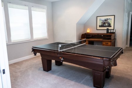 A game room or bonus upstairs room with a pool table converted to a table tennis game.