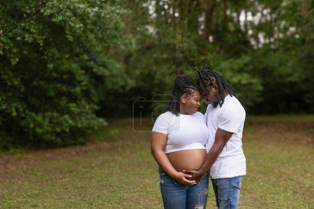A beautiful African-American couple posing for maternity portraits as they are expecting a new baby.