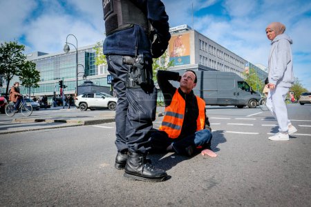 Berlin, Germany - April 24, 2023: Protesters from the group Last Generation sitting on the street and blocking traffic in Berlin, Hermannplatz. High quality photo