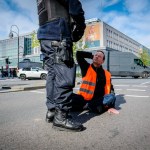 Berlin, Germany - April 24, 2023: Protesters from the group Last Generation sitting on the street and blocking traffic in Berlin, Hermannplatz. High quality photo