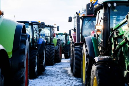 Téléchargez les photos : Bauska, Lettonie - 5 février 2024 : Manifestation des agriculteurs dans la ville lettone de Bauska. Les agriculteurs bloquent la circulation dans la ville avec des tracteurs. Photo de haute qualité - en image libre de droit
