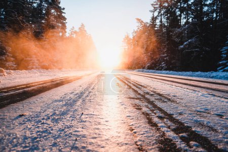 Snowy road outside the city. Ice on the highway on a cold winter day. Traffic in winter. High quality photo