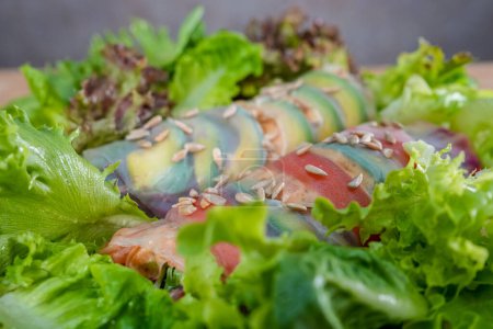 Foto de Rollo de salmón con verduras en plato, sobre mesa de madera, primer plano - Imagen libre de derechos