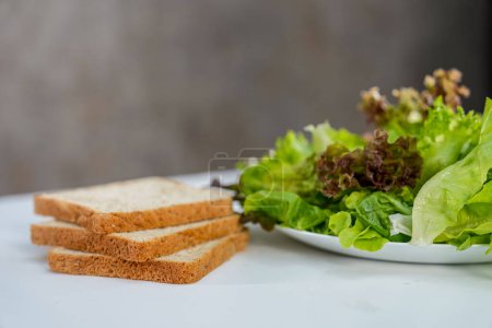 Photo for Vegetable salad and whole wheat breds on white background - Royalty Free Image