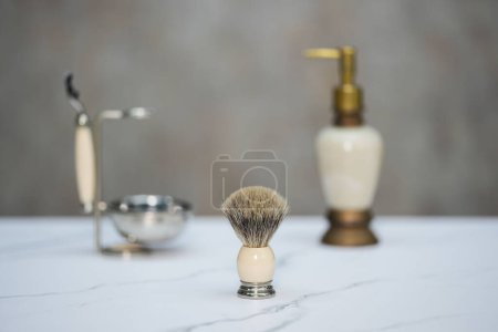 Téléchargez les photos : Une brosse à crème à raser, une poignée de rasoir et une bouteille de pompe se trouvent à côté. - en image libre de droit