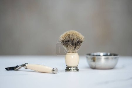 Téléchargez les photos : Un pinceau pour appliquer de la crème à raser, avec une poignée de rasoir à côté - en image libre de droit