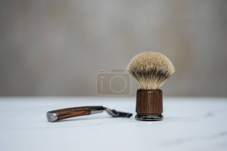 Photo for A brush for applying shaving cream, with a razor handle next to it - Royalty Free Image