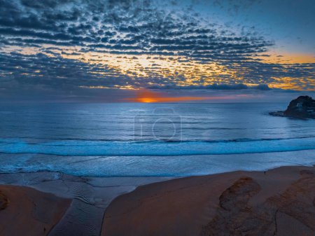 Foto de Salida del sol aéreo en la orilla del mar con nubes medianas que se extienden a través del cielo en Avoca Beach en la costa central, NSW, Australia. - Imagen libre de derechos