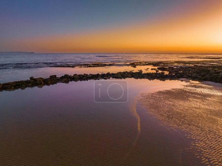 Photo for Aerial sunrise seascape from the sheltered bay of Cabbage Tree Harbour at Norah Head, NSW, Australia. - Royalty Free Image