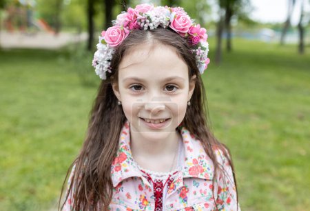 Foto de Retrato de una linda chica ucraniana de 7 años en una corona de flores. Los niños quieren vivir en paz y tranquilidad. Apoya y ayuda a Ucrania. Esté orgulloso de que usted es ucraniano - Imagen libre de derechos