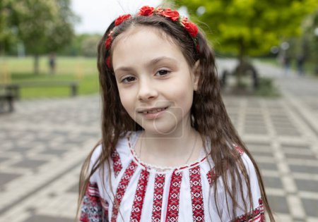 Photo for Cute girl 6-7 years old in a national Ukrainian blouse with an ornament and a wreath in her hair. Ukrainian children for peace. Support Ukraine - Royalty Free Image