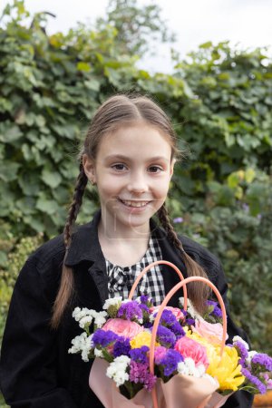 Téléchargez les photos : Portrait d'une heureuse fille de 8 ans avec un bouquet de fleurs multicolores. joyeux enfants émotionnels, enfant positif, humeur festive. Cadeau de fleur pour la fête des mères, fille d'anniversaire - en image libre de droit