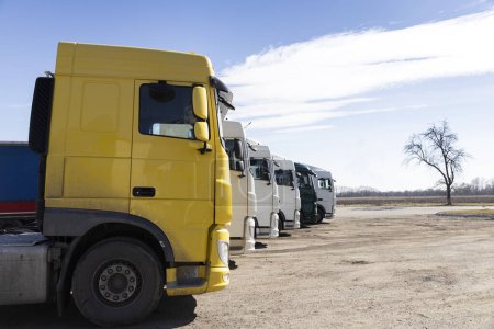Varios camiones estacionados en fila en un día soleado. vista de las cabinas de los tractores-remolques. Vehículos comerciales, coches para el transporte de negocios