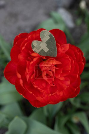 large red flower and heart cut from camouflage military fabric. Stop the war. With love and gratitude to the soldiers of the Armed Forces. symbol of memory of soldiers who died in the war. Victory Day