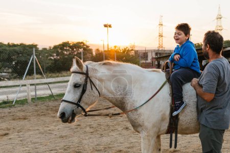 Child with disabilities having fun while enjoying a horseback ride. Equine therapy concept.