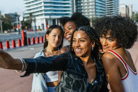 Vista lateral de mujeres multiétnicas y personas transgénero tomando una selfie en la ciudad