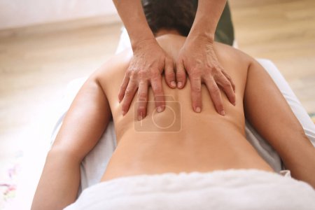 Photo for Hands pressing back of woman in massage center in close up shot and from above - Royalty Free Image