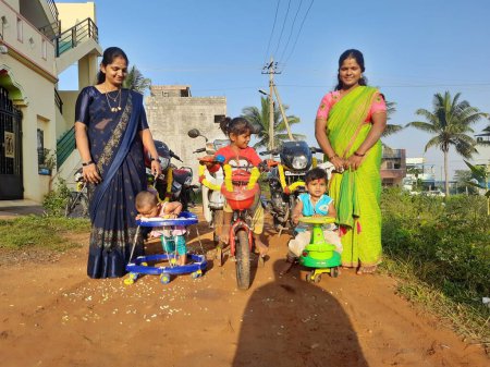 Téléchargez les photos : Bangalore, Karnataka, Inde-Oct 24, 2023 : Gros plan de la belle famille indienne faisant Puja véhicule célébrant Dasara, Ayudha Pooja en face de la maison. - en image libre de droit