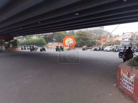 Foto de Bangalore, Karnataka, India-Jan 24, 2024: Primer plano de la señal de tráfico del banco Devegowda Petrol con vehículos y pancarta rama prana pratishtha en el círculo. - Imagen libre de derechos