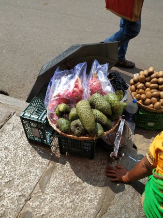 Nahaufnahme von schönen Drachenfrüchten, Kiwi und Guyabano oder Sauerampferfrüchten, die auf einem Holzkorb am Straßenrand verkauft werden.