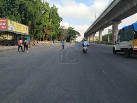 Foto de Bangalore, Karnataka / India-Abr 20 2020: Primer plano de la hermosa carretera de asfalto de Bangalore con el puente de metro Namma o Flyover en un lado cerca de Goraguntepalya. Debido a Covid 19 Lock down Road está vacío. - Imagen libre de derechos