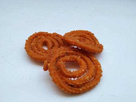 Grupo y primer plano de Chakli aislado sobre fondo blanco. Snack indio Chakli o chakali hecho de porciones fritas de masa de harina de lentejas