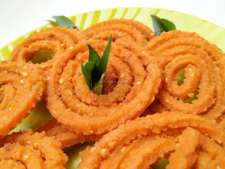 Group and Closeup of Chakli isolated on White Background. Indian Snack Chakli or chakali made from deep frying portions of a lentil flour dough
