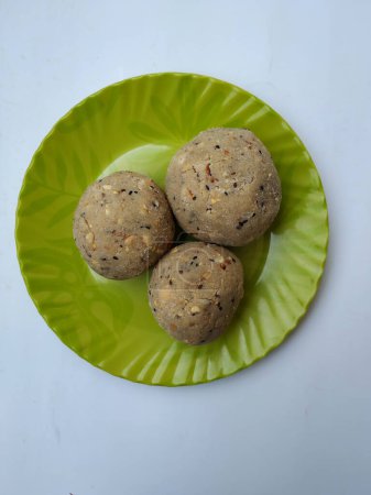 Tambittu or Rice flour laddoo in a Green Color Plate isolated on white background. It is a Indian Festival Home made Festival Food.