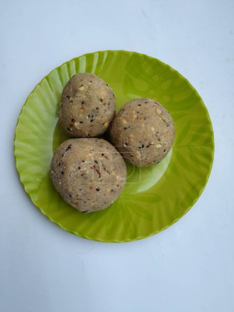 Tambittu o laddoo de harina de arroz en una placa de color verde aislado sobre fondo blanco. Es un festival indio hecho en casa Festival Food.