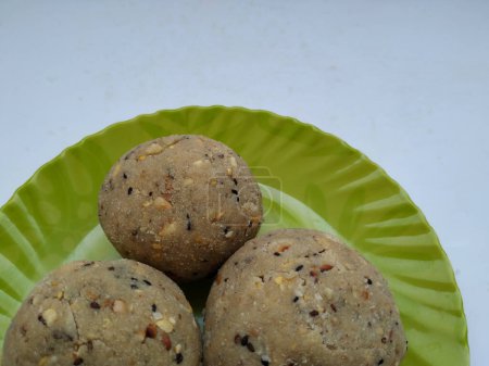 Tambittu o laddoo de harina de arroz en una placa de color verde aislado sobre fondo blanco. Es un festival indio hecho en casa Festival Food.