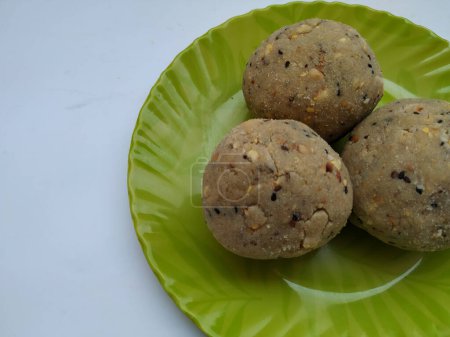 Tambittu or Rice flour laddoo in a Green Color Plate isolated on white background. It is a Indian Festival Home made Festival Food.