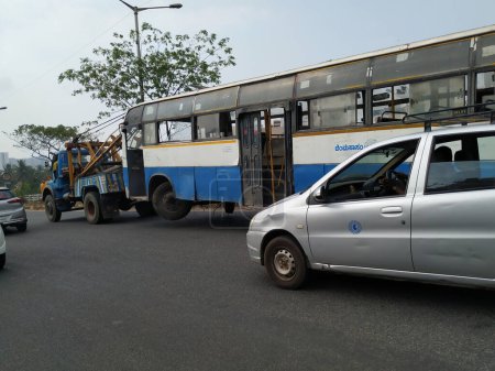 Photo for Bangalore, Karnataka, India-Mar 20 2020: Tow truck delivers the damaged BMTC Bus, Repair and recovery vehicle towing a broken city bus. - Royalty Free Image