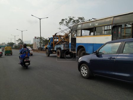 Photo for Bangalore, Karnataka, India-Mar 20 2020: Tow truck delivers the damaged BMTC Bus, Repair and recovery vehicle towing a broken city bus. - Royalty Free Image